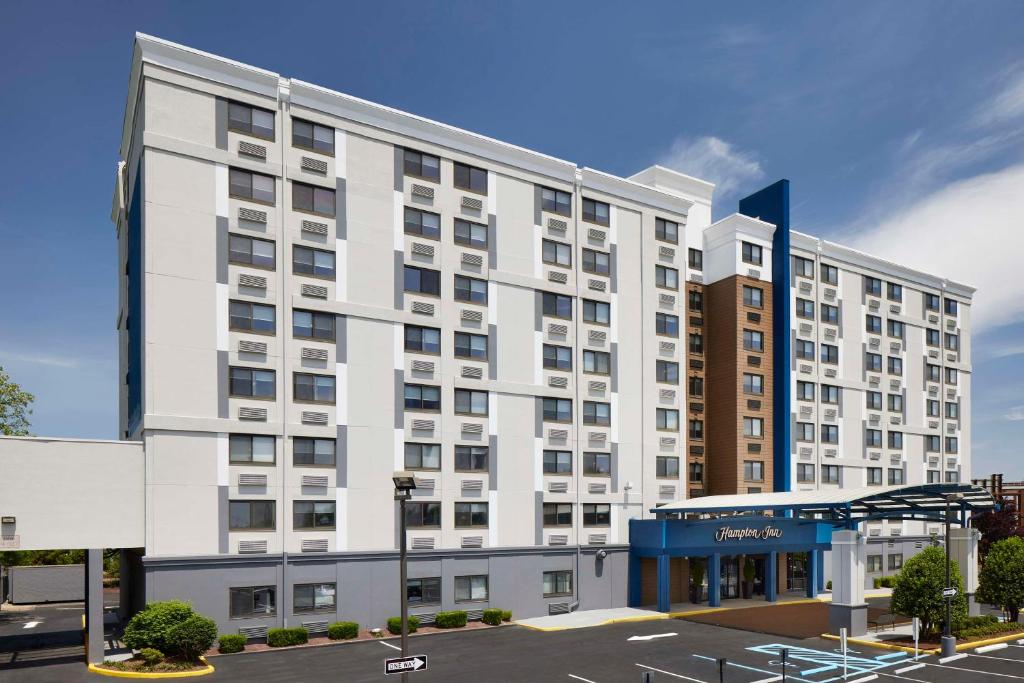 纽瓦克Hampton Inn Newark Airport的一座大型白色建筑,设有停车场