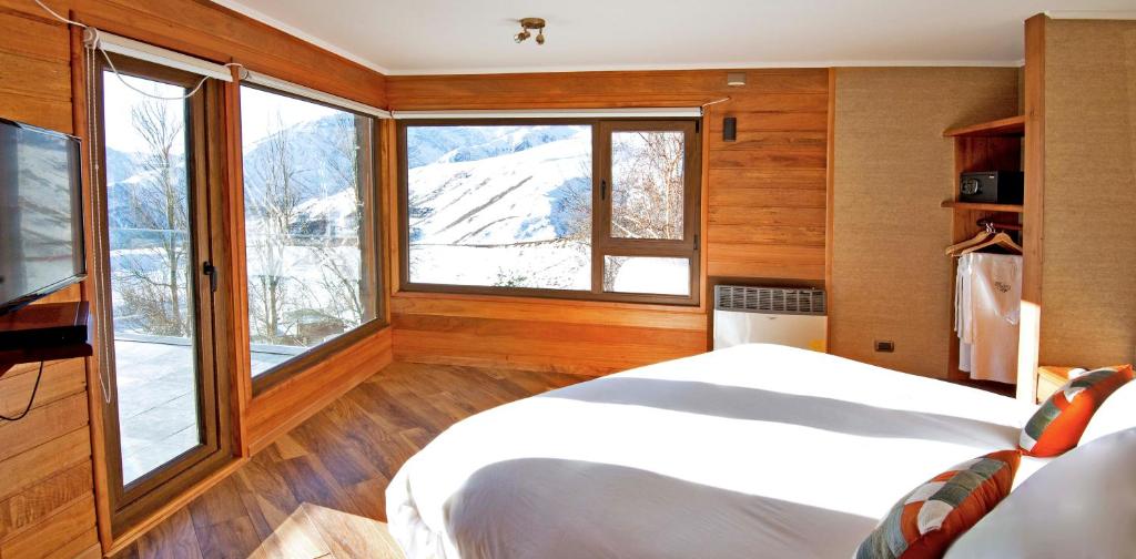 圣地亚哥La Cornisa Lodge的一间卧室设有一张床和一个大窗户