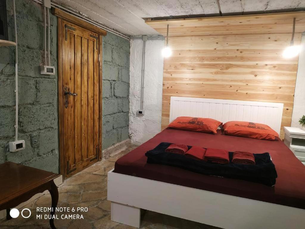 波德戈里察Villa Old Town的一间卧室配有一张木墙床