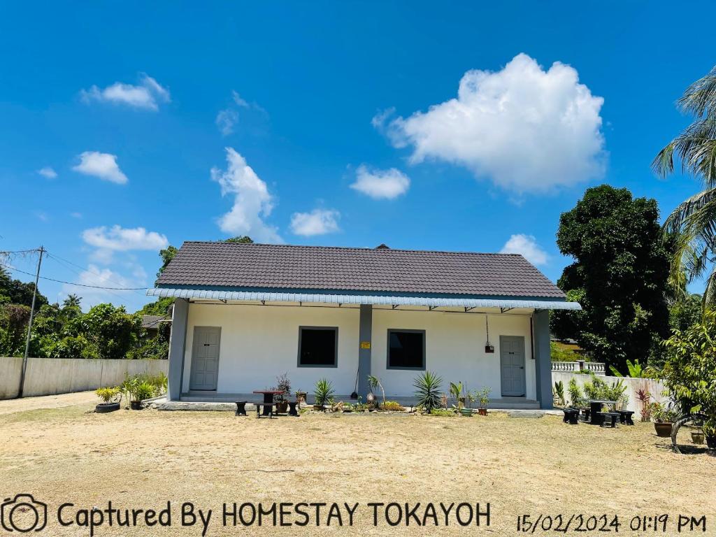 哥打巴鲁Homestay Studio TOKAYOH的蓝色天空的白色小房子