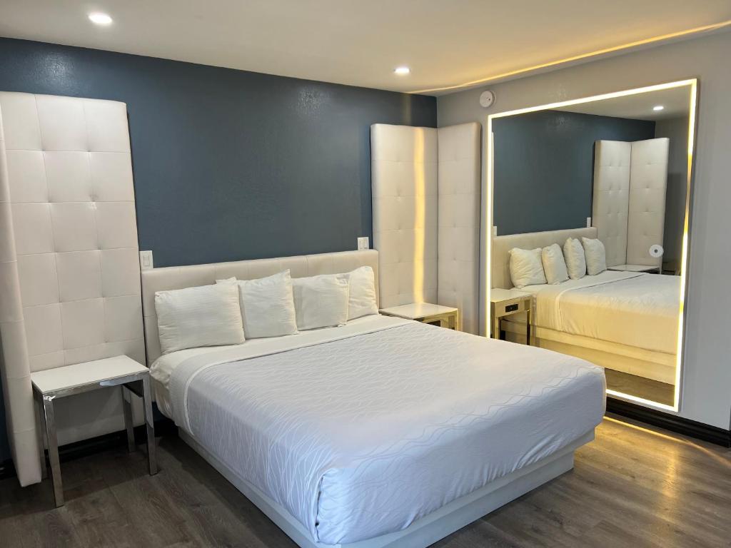 圣路易斯-奥比斯保Hotel Calle Joaquin - San Luis Obispo的卧室配有一张白色大床和镜子