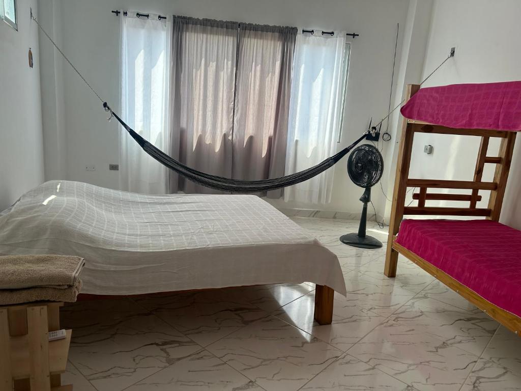 Puerto EscondidoCabaña Maríamar2的一间卧室配有吊床、一张床和一个窗户。