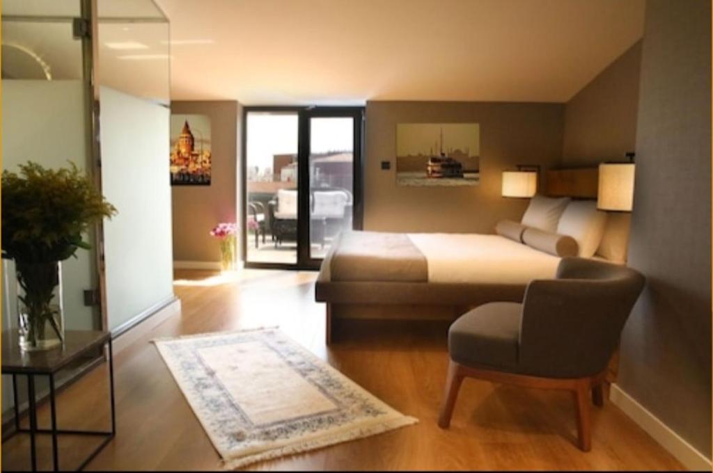 伊斯坦布尔Roomers Nisantasi的一间卧室,卧室内配有一张床和一把椅子