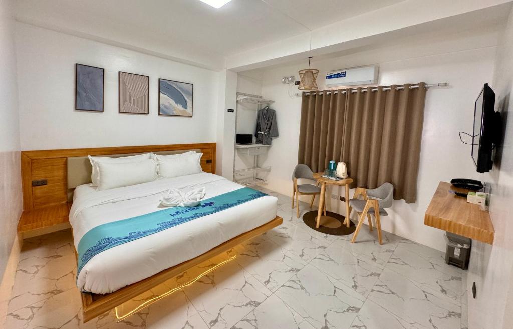 长滩岛LuckyTito Dmall Boracay的一间卧室配有一张床和一张书桌