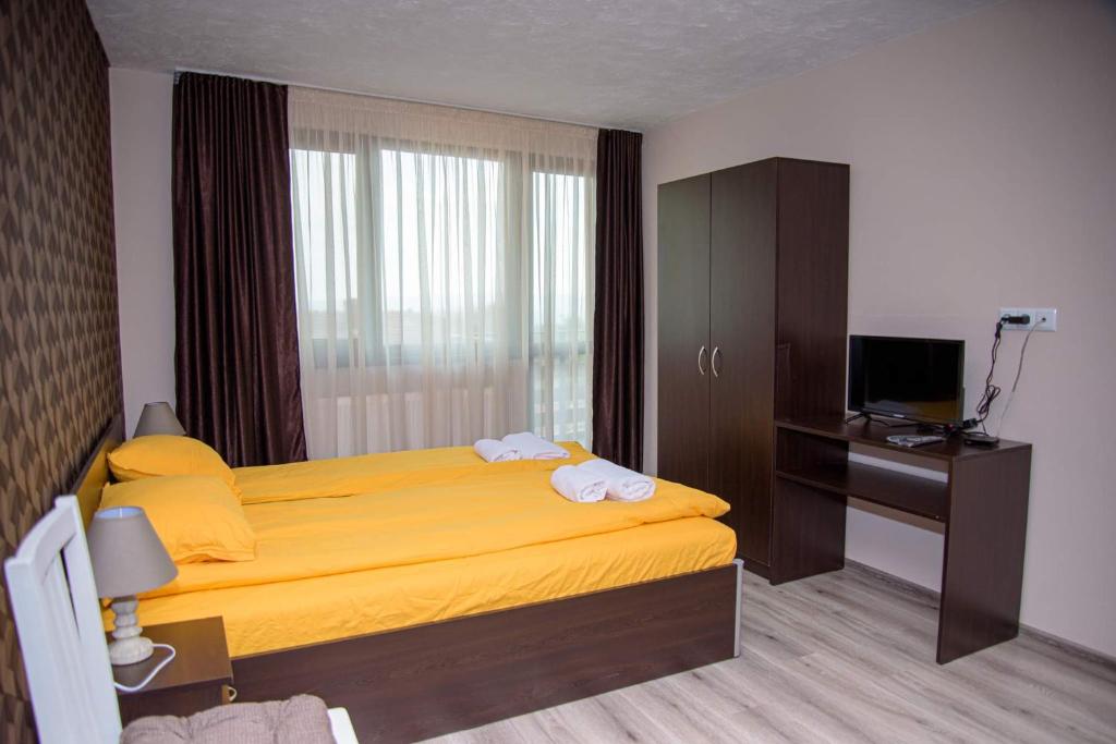 希普卡Вила Здравец的一间卧室配有黄色的床和电视
