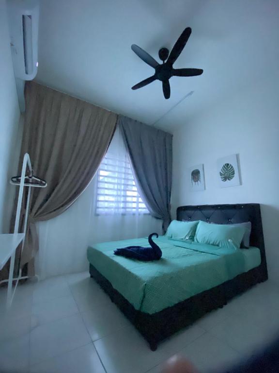 斯里伊斯兰德Abu Fateh Homestay的卧室配有吊扇,床上有一只黑鸟