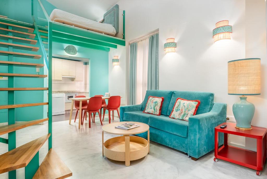 塞维利亚Smartr Sevilla Las Dueñas的客厅配有蓝色的沙发和桌子