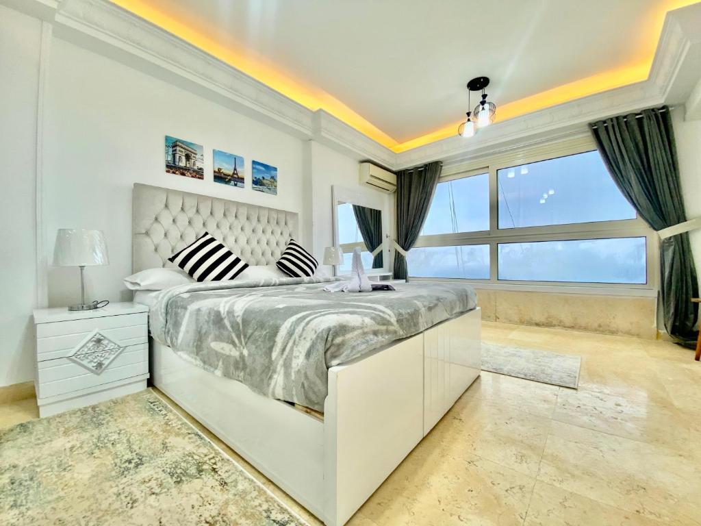 亚历山大Alexandria Luxury Apartments Stanley Direct Sea View的白色的卧室设有一张大床和一个窗户