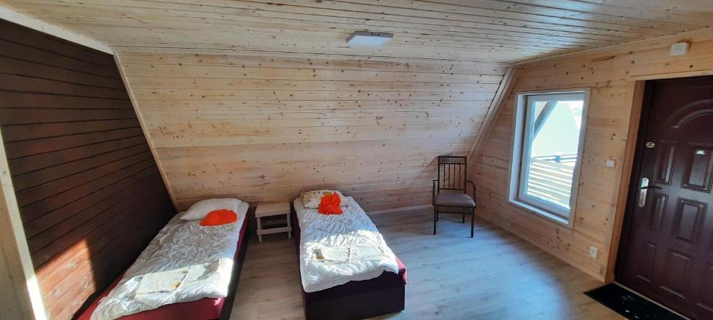 希隆斯克地区扎古热Kolorowe Wzgórze Zagórze的小木屋内带两张床的房间