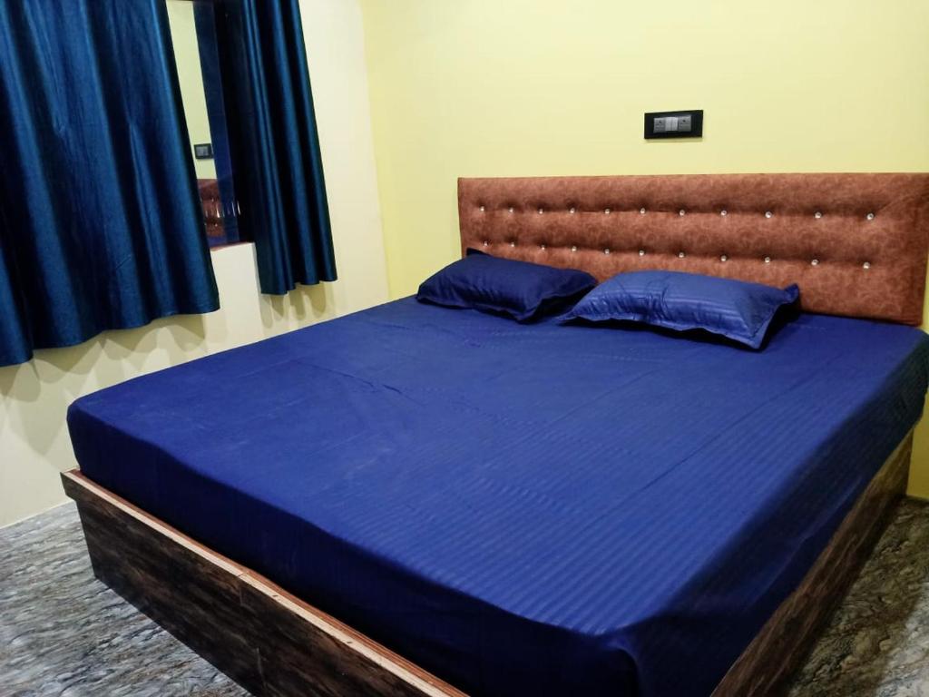 巴德里纳特Badrinath Jbk by Prithvi Yatra Hotel的卧室内的一张带蓝色床单和枕头的床