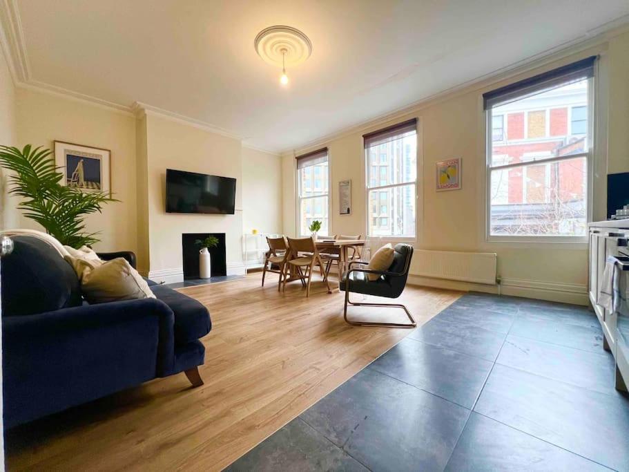 伦敦4 Bed Apartment- Archway Station的客厅配有蓝色的沙发和桌子