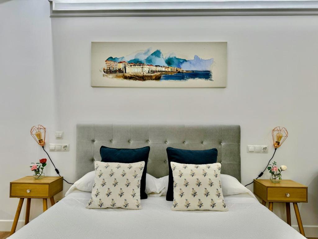桑坦德LOFT CENTRE SANTANDER的一间卧室配有一张带蓝色枕头的床和一幅画