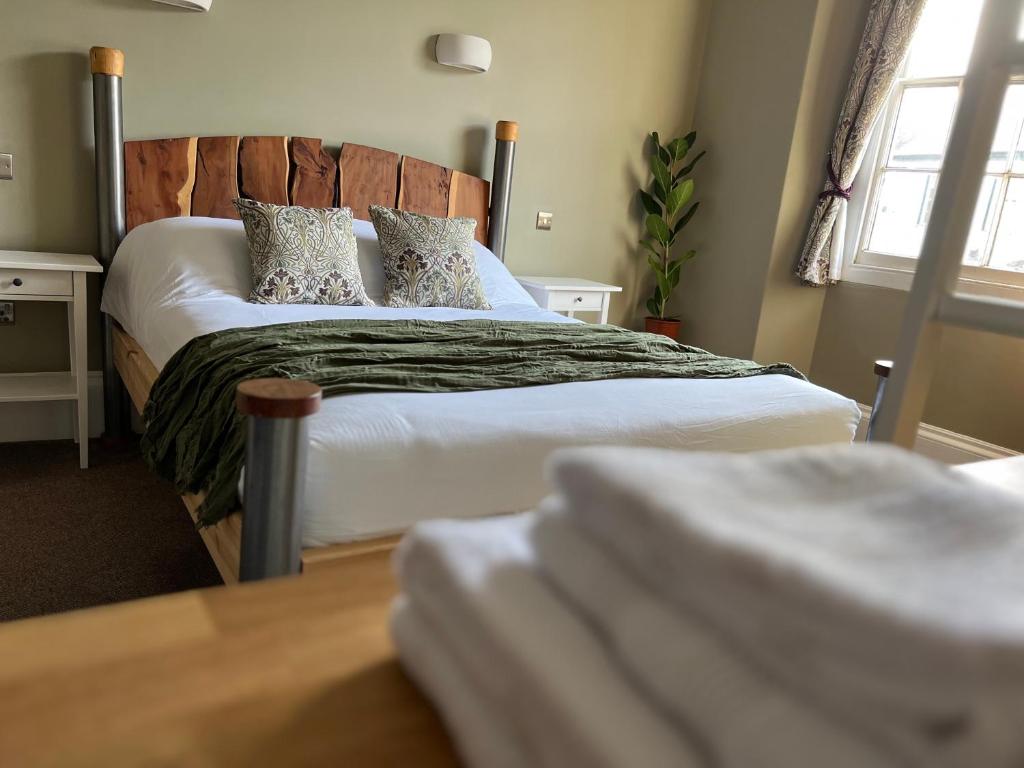 卡伦普顿The Roost的一间卧室配有带白色床单和枕头的床。