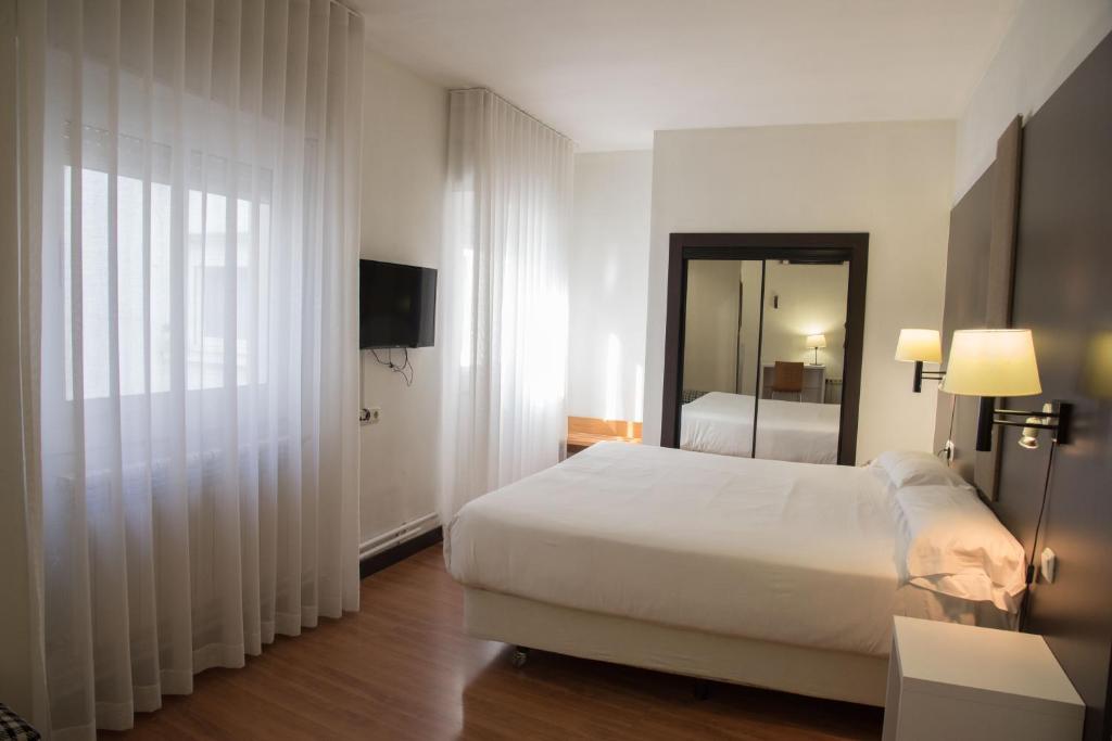 图德拉德尔塔酒店的酒店客房,配有床和电视
