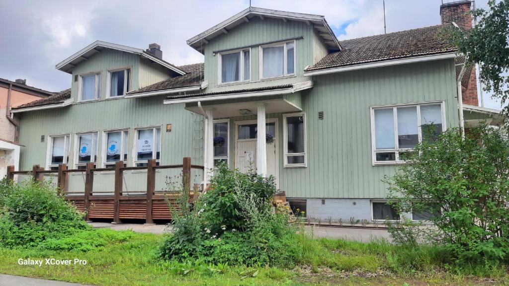 奥卢Oulun Satamahuoneet的绿色房屋,设有木栅栏