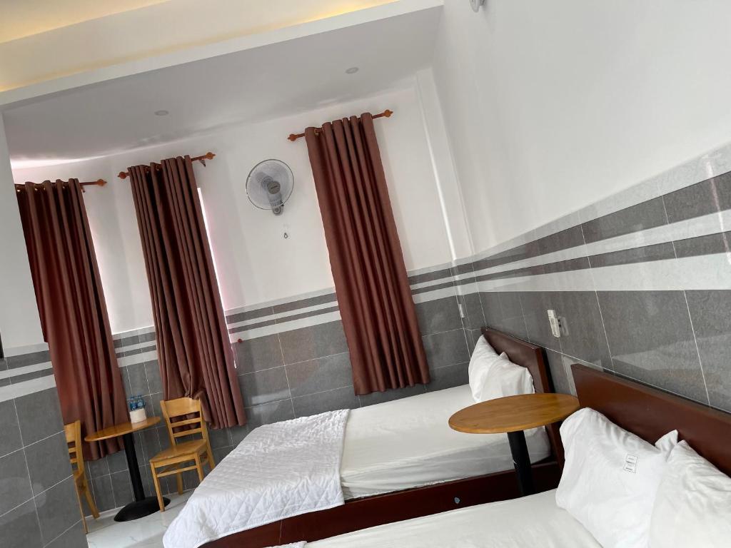 Tràm ChimVIEW HOTEL-TRÀM CHIM的酒店客房设有两张床和一张桌子。