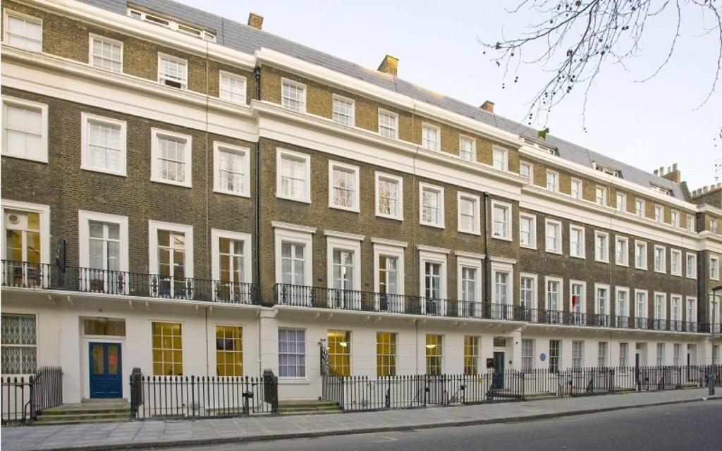 伦敦Campbell House的一座大型砖砌建筑,设有黄色门窗