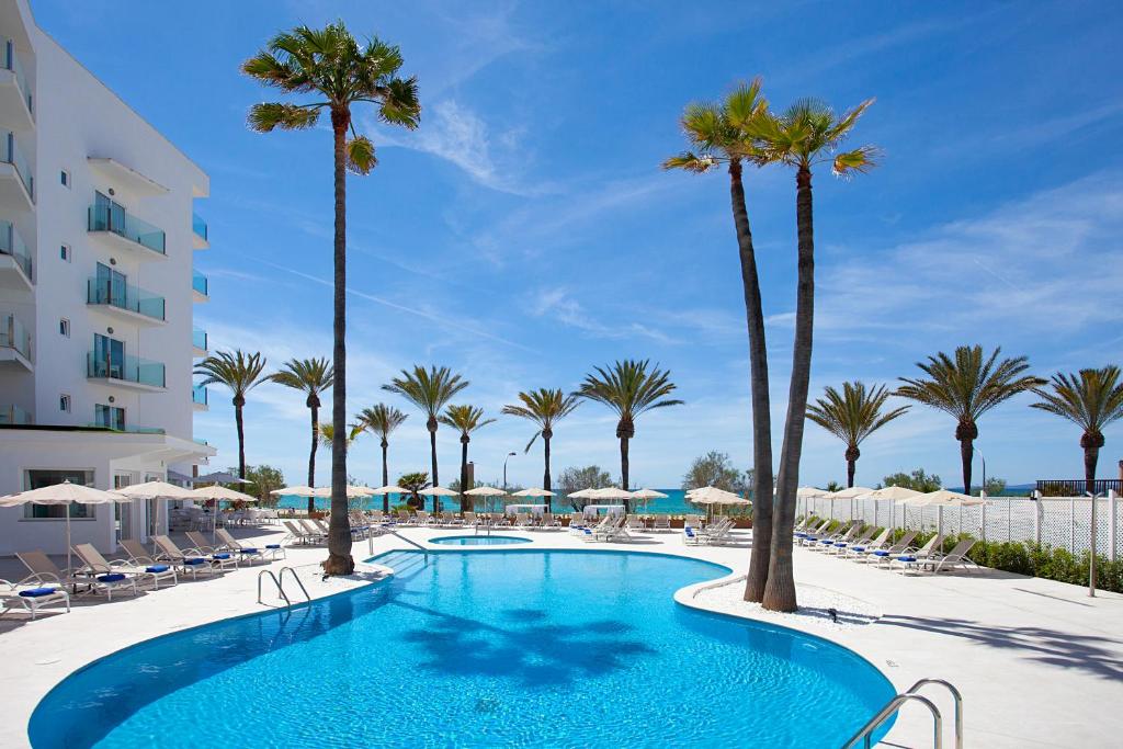 帕尔马海滩HSM Golden Playa的一座棕榈树游泳池和一座建筑