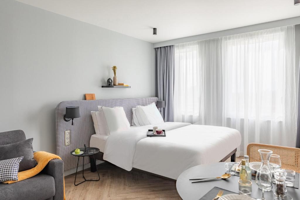鲁瓦西昂法兰西Appart'City Collection Paris Roissy CDG Airport的酒店客房配有一张床铺和一张桌子。