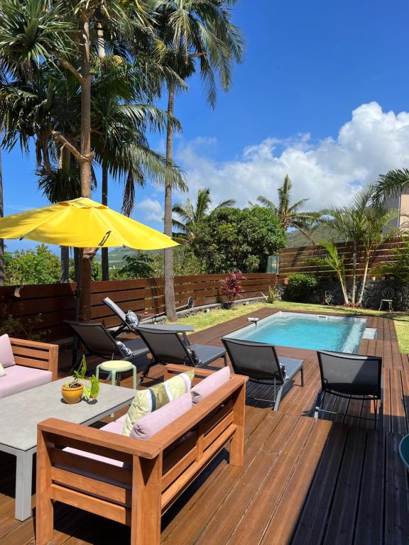 圣若瑟Maison avec piscine chauffée - 8 personnes - Sud Réunion的一个带桌椅的甲板和一个游泳池