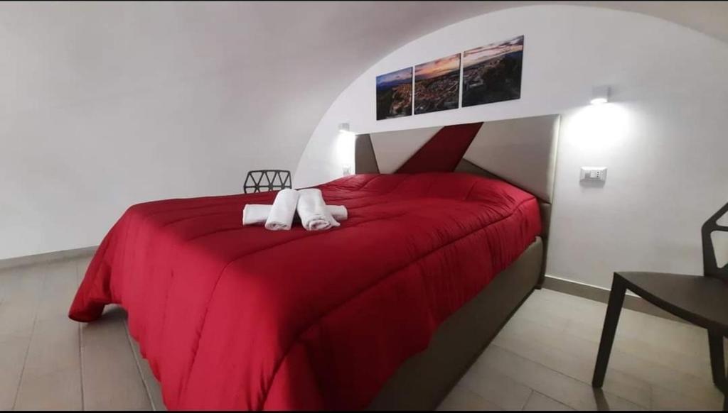 圣安吉罗山Casa MaLù 18的一张红色的床,上面有两条白色毛巾