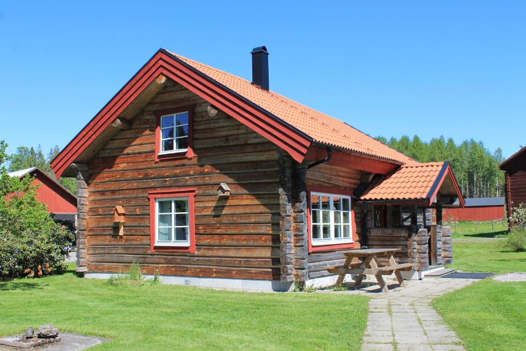 GårdsjöFårgården Åsebol的小木屋前方设有野餐桌