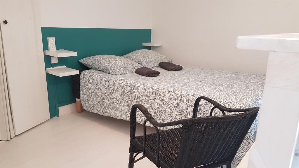巴黎Chambre cosy dans petit loft的一间小卧室,配有一张床和一把椅子
