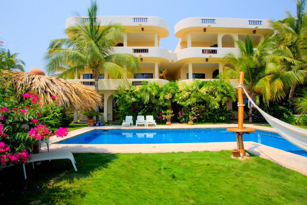 埃斯孔迪多港Las Turquezas的一个带游泳池和庭院吊床的度假胜地