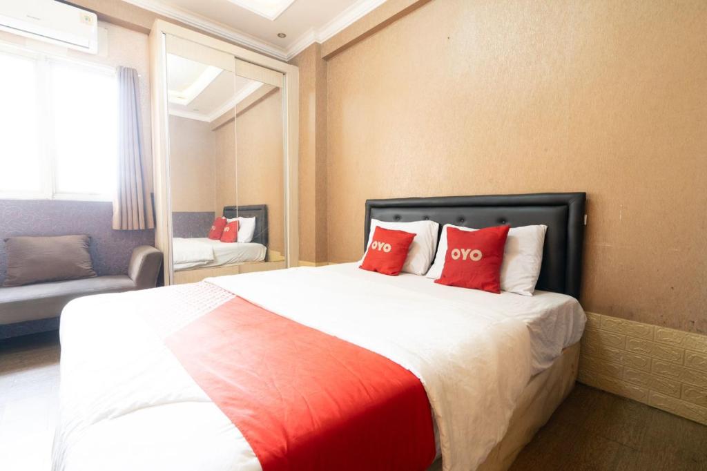 万隆THE SUITES METRO BY GOODVIBES APARTMENT的一间卧室配有一张带红色枕头的大床