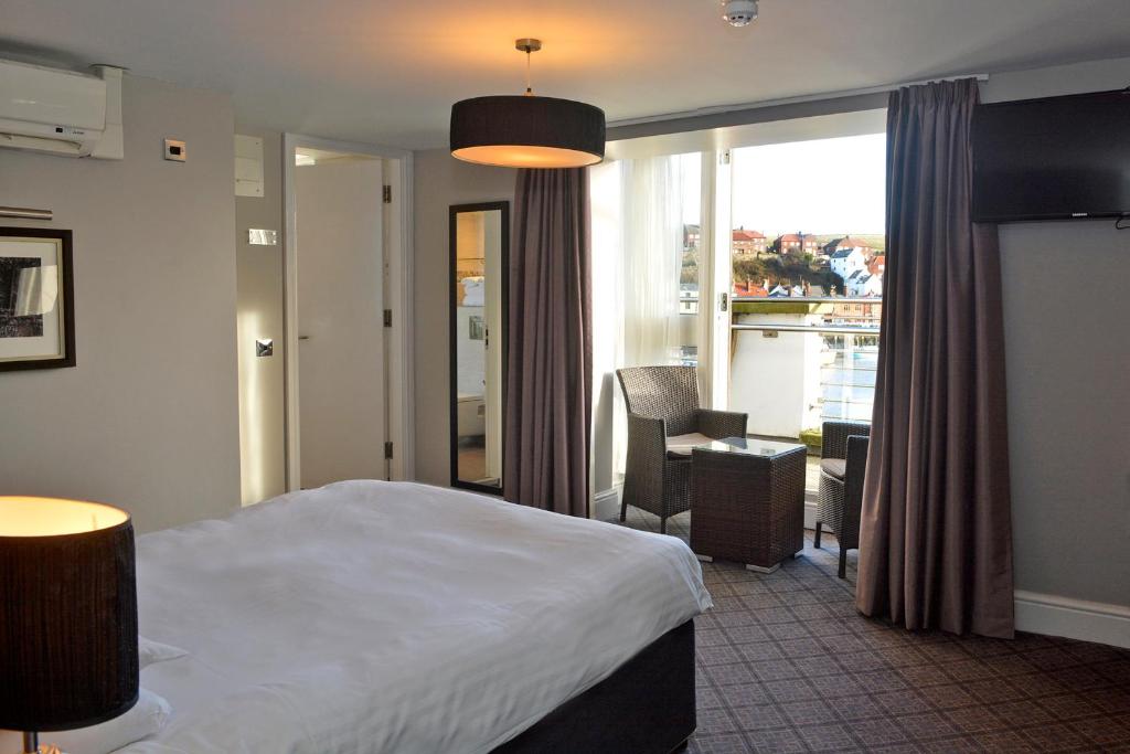 惠特比威瑟斯本安琪尔酒店的配有一张床、一张书桌和一扇窗户的酒店客房