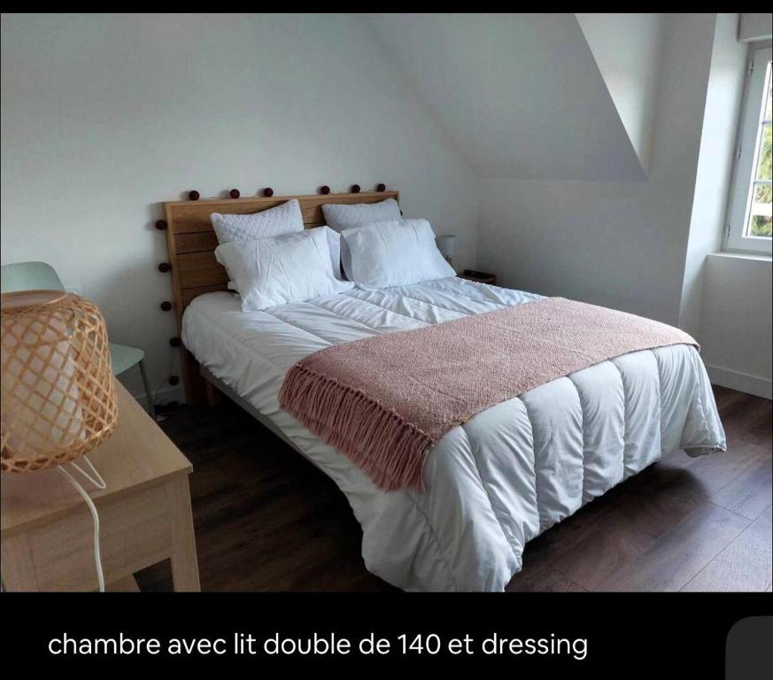 富埃南Duplex Cosy 100m2 Terrasse Fouesnant Les Glénan的卧室配有一张带白色床单和枕头的大床。