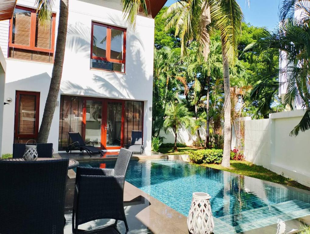 盼武里普拉纳鲁克斯泳池度假屋旅馆的棕榈树房子后院的游泳池