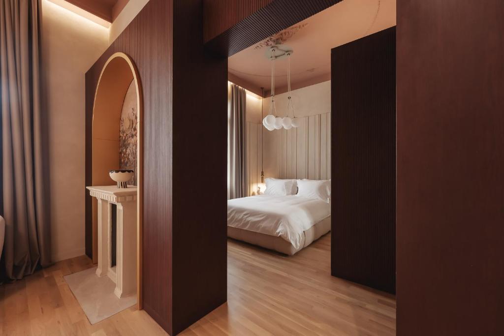 塞萨洛尼基Zenith Premium Suites的酒店客房带一张床和走廊