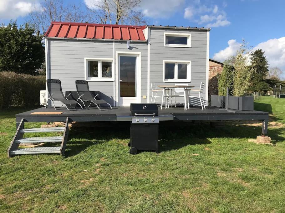 Boissy-sur-DamvilleTiny house à la ferme près Paris et center parcs.的码头上的小房子,有椅子和烤架