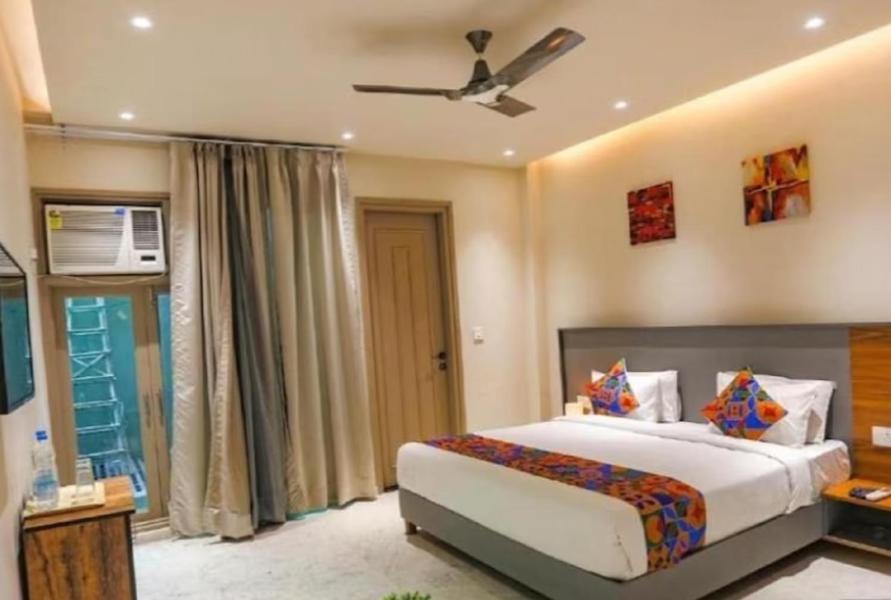 诺伊达HOTEL GLOBAL CORPORATE NOIDA的一间卧室配有一张床和吊扇