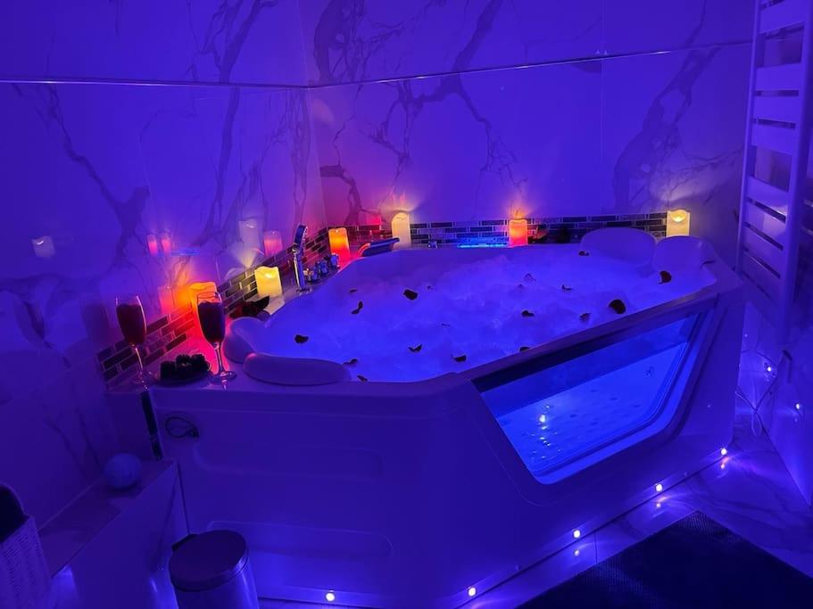 La Celle-Saint-CloudLuxueux Appartement Jacuzzi proche de Paris的一间设有紫色灯床的房间