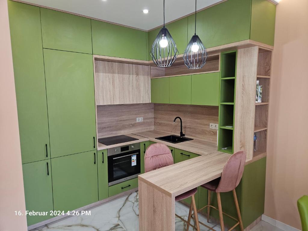 PernikDilyanka的厨房配有绿色橱柜和桌椅