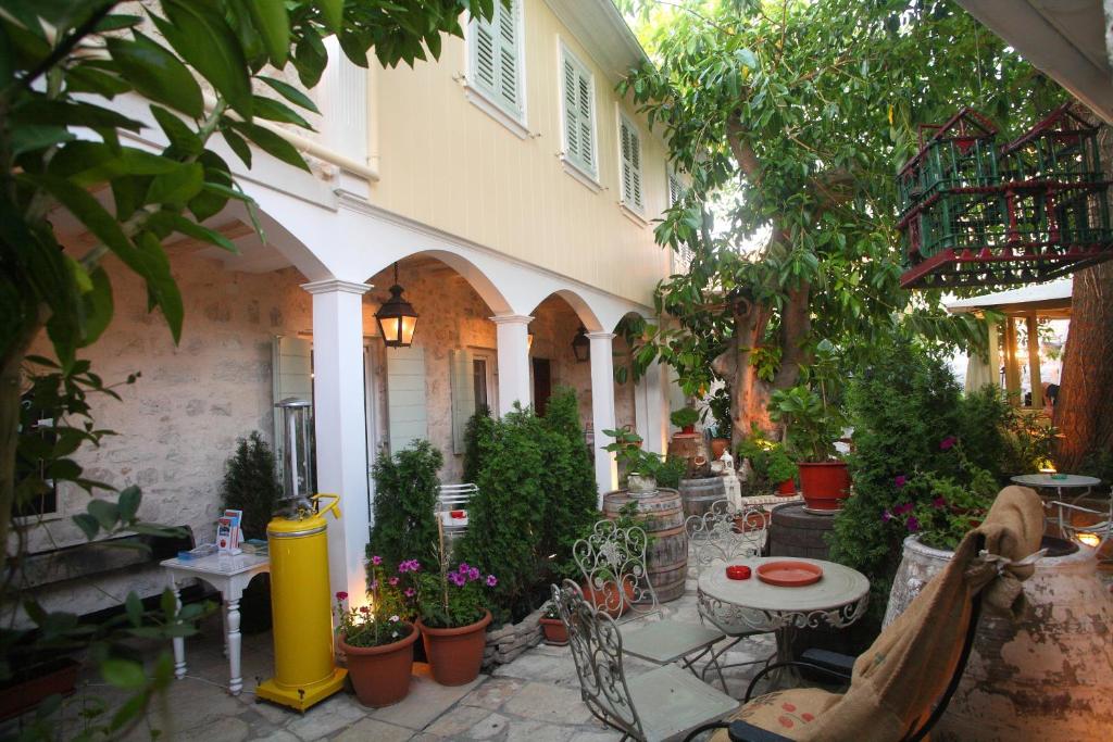 雷夫卡达镇艾格利酒店的户外庭院配有桌椅和植物。