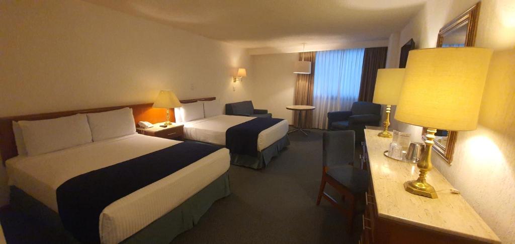 墨西哥城布里斯托酒店的酒店客房配有两张床和一张书桌