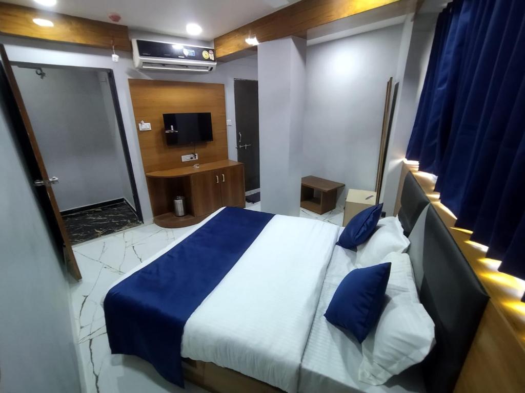 艾哈迈达巴德HOTEL SHREE RADHE的一间卧室配有一张床,浴室配有电视。