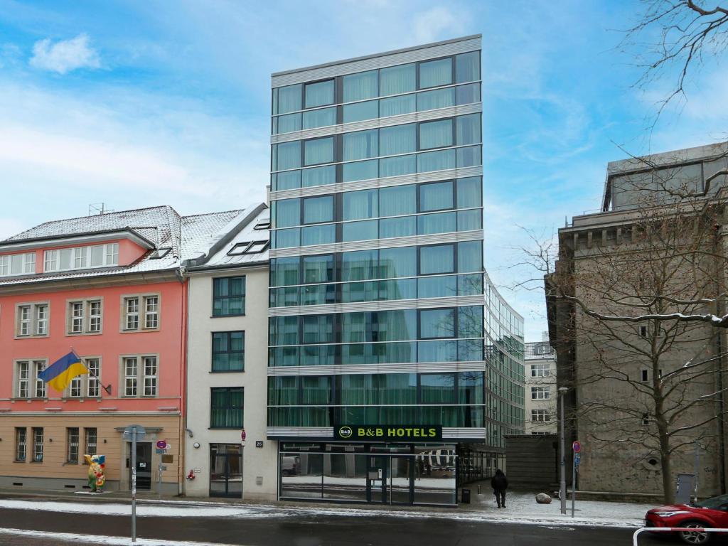 柏林B&B HOTEL Berlin-Mitte的城市街道上一座高大的玻璃建筑