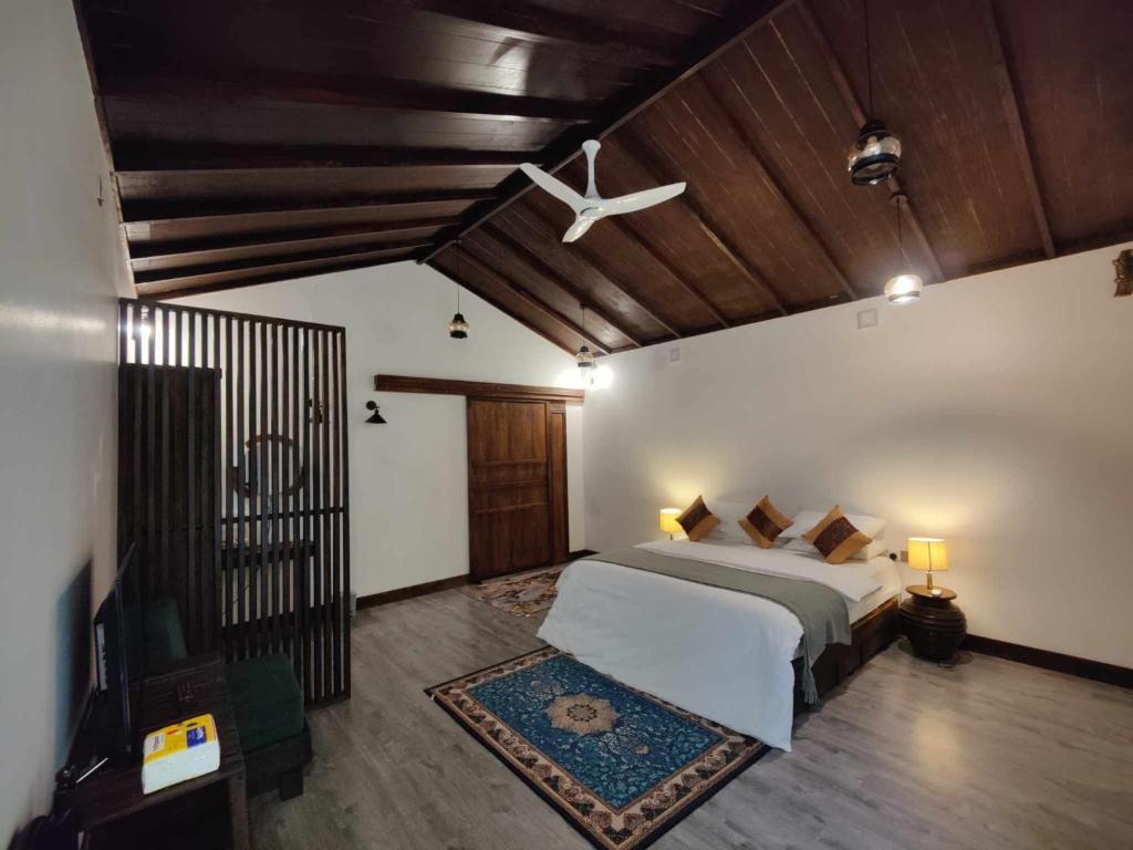 拉斯杜Private Villa by Rashuthere的一间卧室配有一张床和吊扇