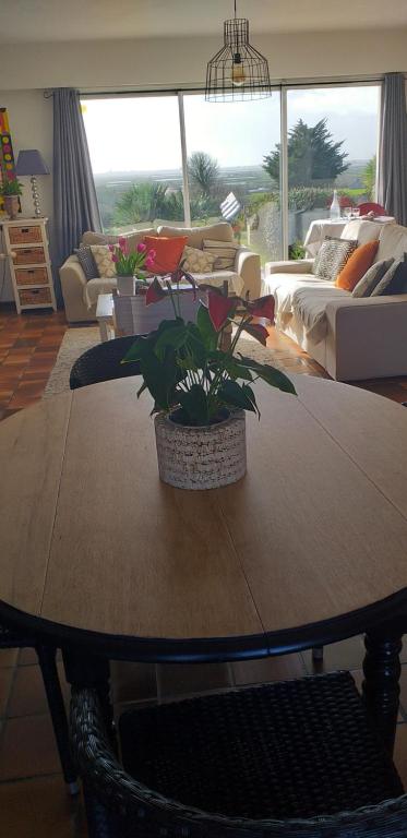 盖朗德chambre avec vue sur les marais salants的客厅配有木桌和植物