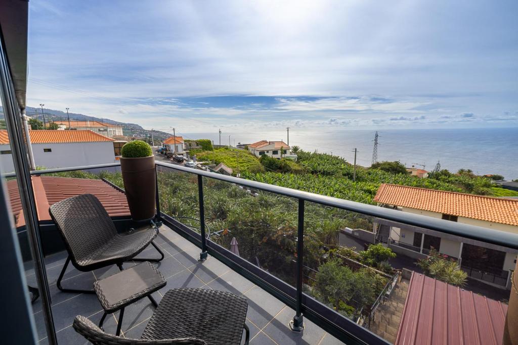 Quinta do AlmeidaPanoramic House的阳台配有两把椅子,享有海景。