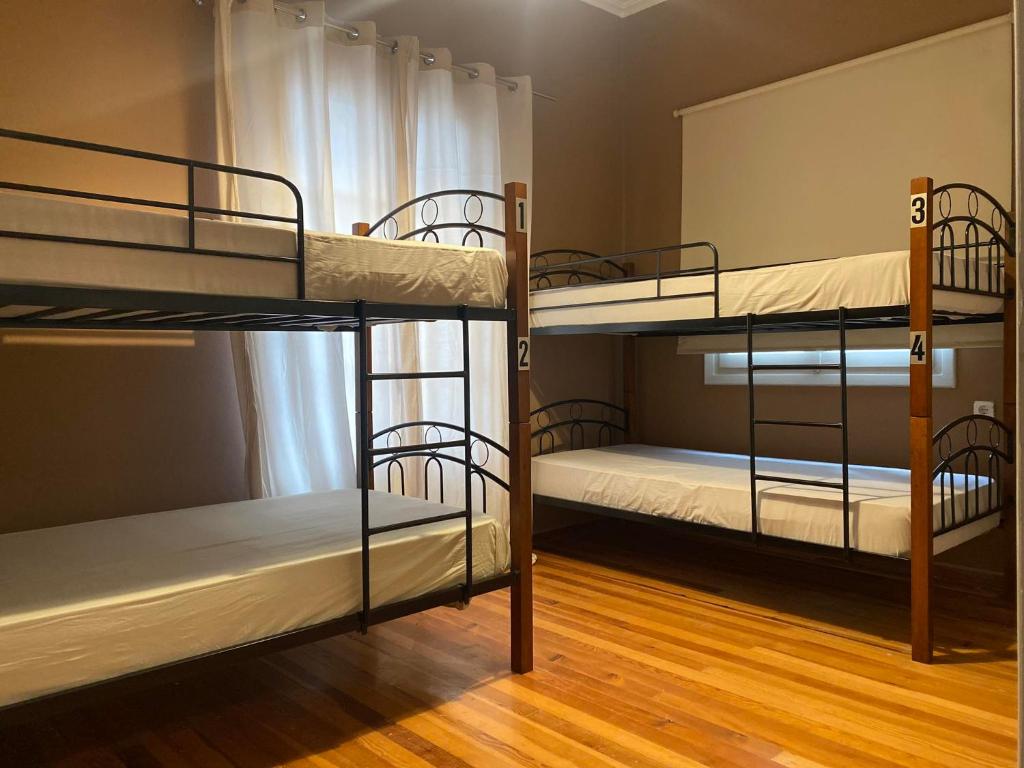 约阿尼纳Lait Hostel的铺有木地板的客房内配有三张双层床。