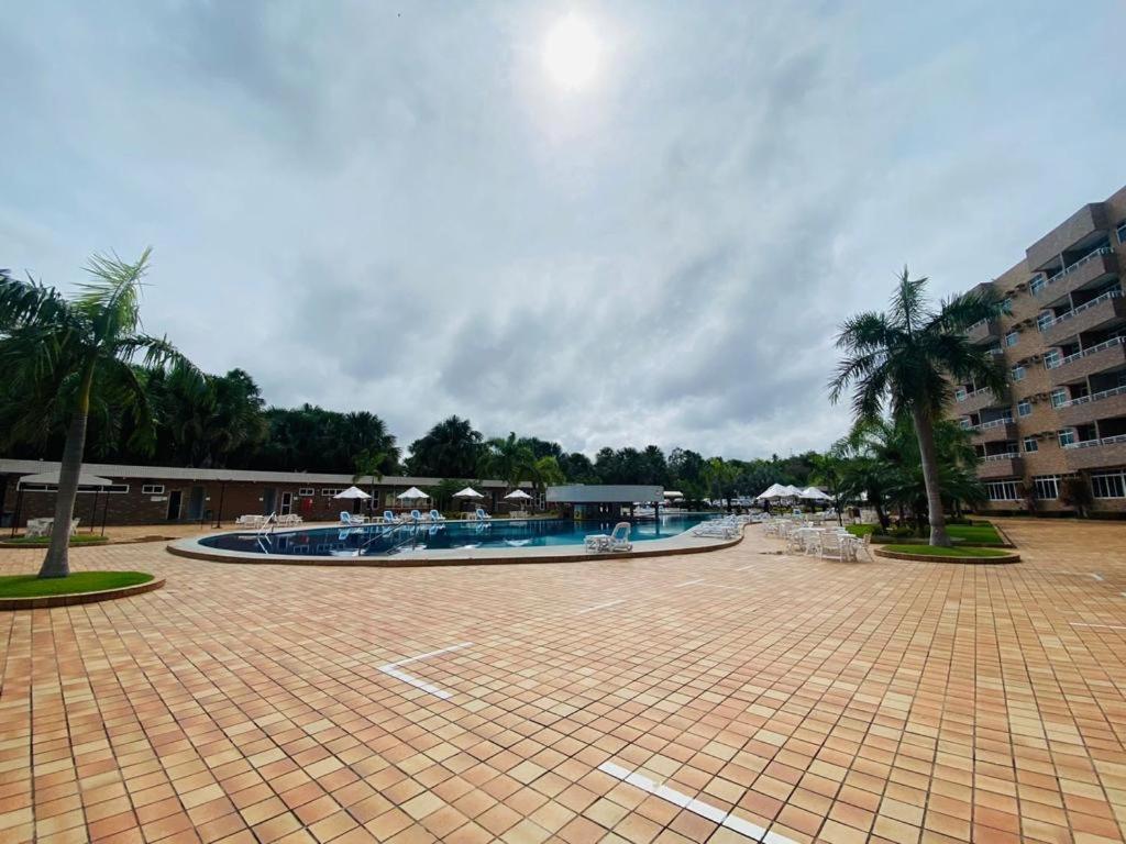 巴雷里尼亚斯Gran Lençóis Flat Residence的庭院内带遮阳伞和椅子的大型游泳池