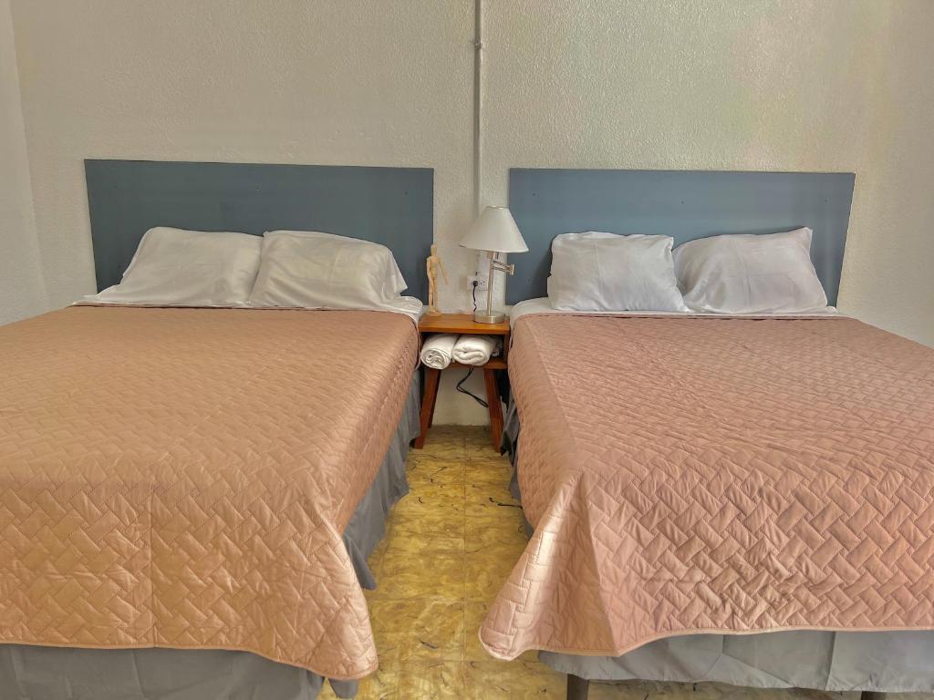 危地马拉Hotel Citadin zona 5的两张睡床彼此相邻,位于一个房间里