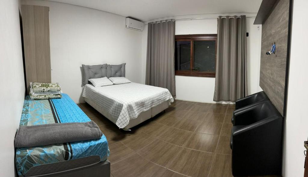 新汉堡市Casa Liberdade的一间卧室配有一张床和一张沙发