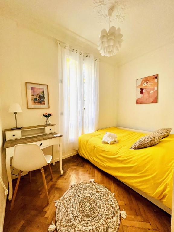 尼斯Cœur d&#39;Azur Appartement的一间卧室配有黄色的床和一张书桌