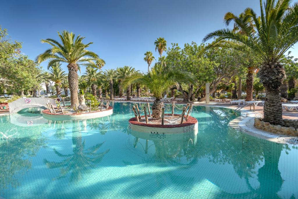哈马马特Mediterranee Hammamet- Families and Couples Only的度假村内棕榈树游泳池
